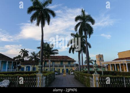 Una bella vista di palme ed edifici a Trinidad sotto il cielo blu Foto Stock