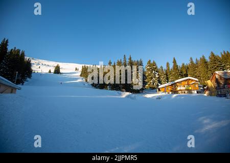 Un fantastico paesaggio invernale con una casa in legno sulle montagne innevate Foto Stock