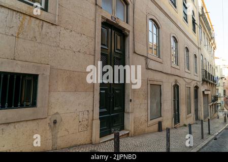 Un colpo di una porta scura in vecchio stile di un edificio con finestre porticato Foto Stock