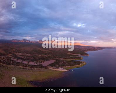 Una vista aerea del lago Roosevelt e le aree boschive vicino alla riva sotto il cielo nuvoloso Foto Stock