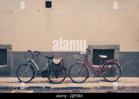 Un colpo di due vecchie biciclette parcheggiate su una parete esterna Foto Stock