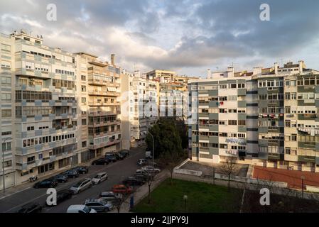 Una lunga esposizione di edifici di appartamenti contro un cielo blu nuvoloso in una giornata di sole, Lisbona, Portogallo Foto Stock