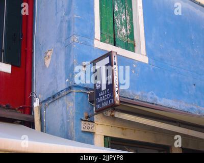 Un antico edificio colorato con l'insegna Tabacchi a Murano Foto Stock
