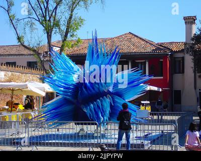 Una scultura in vetro blu in una piazza di Murano sullo sfondo degli edifici Foto Stock