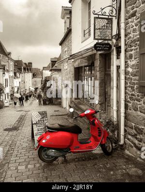 Uno scatto verticale di uno scooter parcheggiato in una tipica strada francese Foto Stock