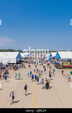 Un'immagine verticale dei visitatori che camminano per la pista all'Airshow EAA AirVenture Foto Stock