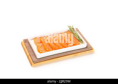 Un primo piano di sushi di salmone con rosmarino su un piatto bianco Foto Stock