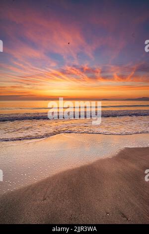 Uno scatto verticale del bellissimo tramonto sulla spiaggia Foto Stock