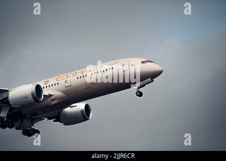 Una foto di un aereo di linea Etihad Airways Boeing 787 Dreamliner in volo con uno sfondo di nuvole scure Foto Stock