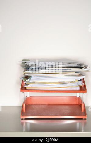 Una foto verticale di una pila di documenti su un supporto carta Foto Stock