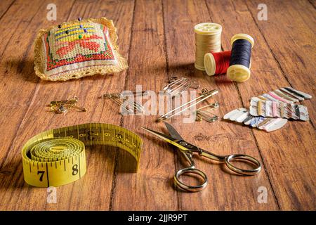 Un set di accessori da cucire su sfondo di legno Foto Stock