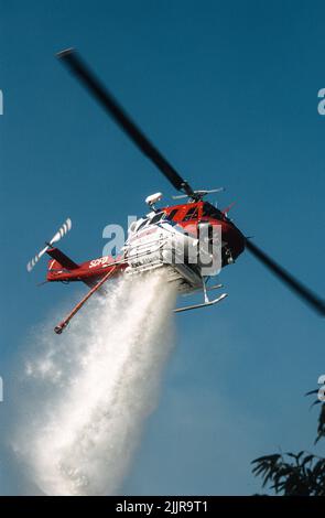 San Diego Fire-Rescue Copter 1 facendo una goccia d'acqua su un fuoco di terra selvatica (pennello) a San Diego, California Foto Stock