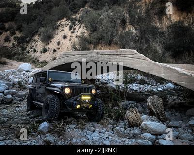 Una Jeep Wrangler JLU nera fuori strada tra le montagne e le colline di Riverside, California Foto Stock