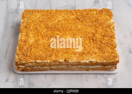 Un primo piano di una fetta di torta Napoleone sulla superficie di marmo bianco Foto Stock