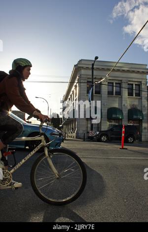 Una foto di una giovane donna è in bicicletta nel quartiere di Mount Pleasant, Vancouver, British Columbia, Canada Foto Stock