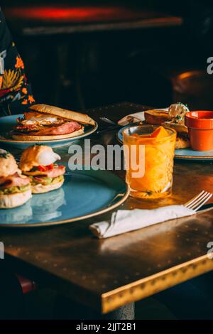 Una colazione appetitosa con deliziosi hamburger e una bevanda rinfrescante Foto Stock