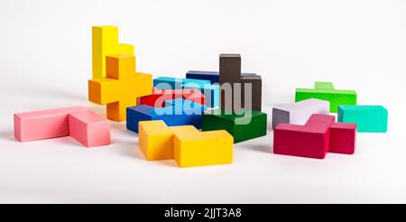 Elementi giocattolo puzzle multicolore. Caos, disordine, concetto di inizio del lavoro. Gioco per bambini in legno per lo sviluppo del pensiero logico. Foto di alta qualità Foto Stock