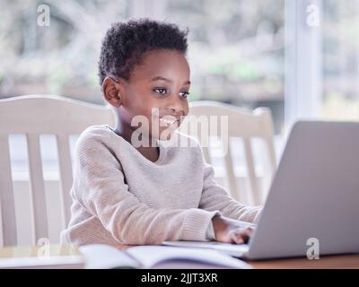 Studia con impegno cosa ti interessa di più. Un ragazzo che fa i compiti su un notebook a casa. Foto Stock