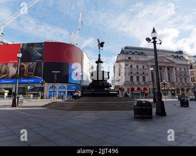 Londra, Grande Londra, Inghilterra, 02 2022 luglio: Piccadilly Circus quasi vuoto con poche persone sedute sui gradini del Shaftesbury Memorial Fount Foto Stock