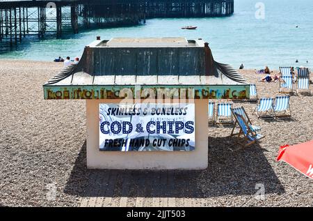 Brighton Beach UK - rifugio sul mare con pubblicità Cod & Chips senza pelle e disossamento sul lato Foto Stock