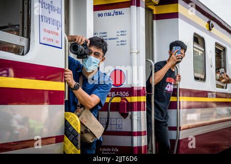 Bangkok, Tailandia. 28th luglio 2022. Un fotografo scatta foto all'esterno di un treno mentre inizia a muoversi. I fan reali e gli appassionati di treno si riuniscono sulla piattaforma in direzione nord alla stazione di Hua Lamphong a Bangkok per un viaggio commemorativo in treno a vapore ad Ayutthaya (l'ex capitale del Siam) in occasione del 70th compleanno del re HM Vajiralongkorn il 28 luglio 2022. Le locomotive a vapore dell'era della seconda guerra mondiale sono state restaurate per un uso limitato e commemorativo per il turismo. Credit: SOPA Images Limited/Alamy Live News Foto Stock