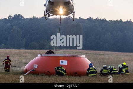 Hrensko, Repubblica Ceca. 27th luglio 2022. Elicottero prendi l'acqua per Bambi Bucket da uno speciale sacchetto di 54,5 metri cubi situato vicino al fuoco e riempito dalle petroliere, Hrensko nel Parco Nazionale Ceske Svycarsko (Svizzera Ceca), Repubblica Ceca, 27 luglio 2022. L'incendio nel parco nazionale si è diffuso per il quarto giorno consecutivo. Credit: Vojtech Hajek/CTK Photo/Alamy Live News Foto Stock