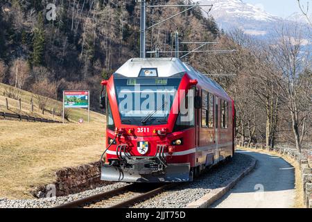 Il famoso treno rosso Alpine Bernina Express sulla strada. Svizzera Foto Stock