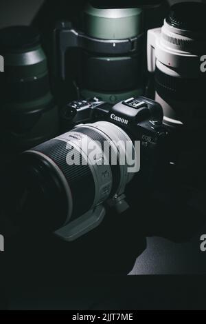 Una Canon EOS R5 con un obiettivo 70 200mm circondato da altri obiettivi Foto Stock
