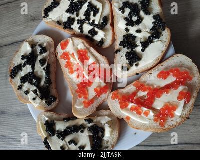 un sandwich con caviale rosso e nero su un piatto Foto Stock