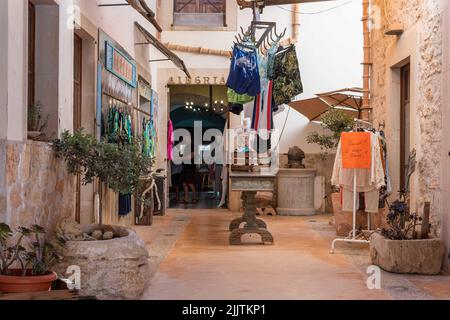 Santanyi, Spagna; luglio 09 2022: Mercato settimanale di strada nella città di Majorcan di Santanyi, Spagna. Bancarelle che vendono abiti e moda con i turisti strollin Foto Stock