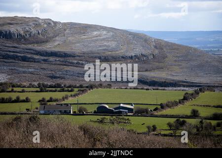 Un bel paesaggio di case e campi agricoli in una zona montagnosa vicino al mare Foto Stock