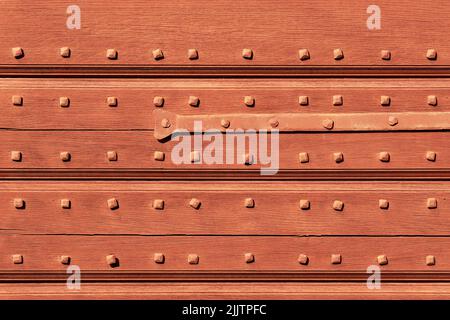 Fondo in legno con chiodi porta magazzino vintage ed elemento in metallo. Architettura rurale. Foto Stock