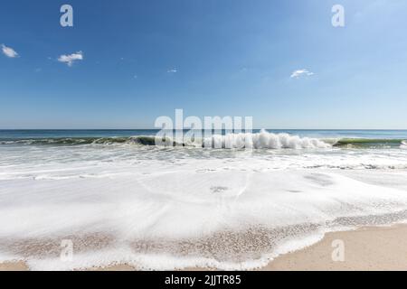 Una vista sulla spiaggia con onde bianche e cielo blu a Point Pleasant Beach NJ, USA Foto Stock