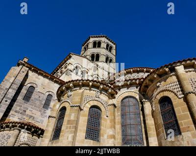 Un colpo basso angolo della chiesa abbaziale di Saint-Austremoine in Issoire con vetrate a motivi geometrici Foto Stock