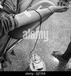 Donatore di sangue al campo di donazione di sangue tenuto con una palla rimbalzante in mano al Tempio Balaji, Vivek Vihar, Delhi, India, Image for World Blood Donor da Foto Stock