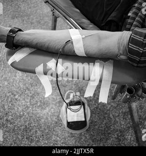 Donatore di sangue al campo di donazione di sangue tenuto con una palla rimbalzante in mano al Tempio Balaji, Vivek Vihar, Delhi, India, Image for World Blood Donor da Foto Stock