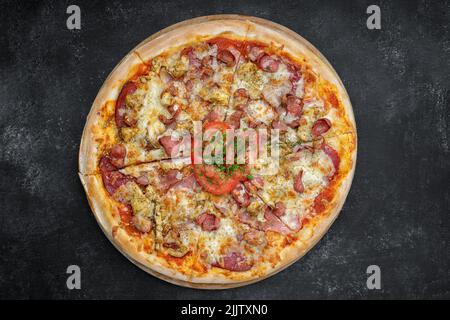 Quattro pizza a base di carne su un asse di legno su cemento grigio Foto Stock