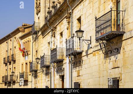 Facciate di vecchi edifici in pietra con i loro tipici balconi con tralicci metallici nel Burgo de Osma, Soria. Foto Stock