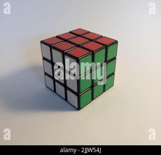 Primo piano di un cubo di Rubik risolto su sfondo bianco Foto Stock