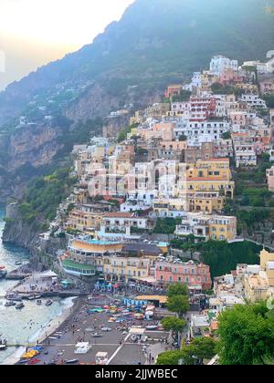 Una foto verticale di case colorate su una collina verde sulla spiaggia di Positano in Italia Foto Stock