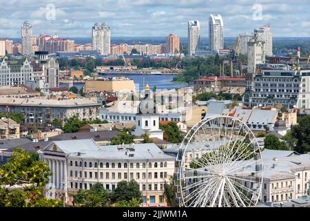 Ruota panoramica nel vecchio quartiere Podil sullo sfondo di nuove case nella zona notte di Obolon all'orizzonte. 07.24.22. Kiev. Ucraina. Foto Stock