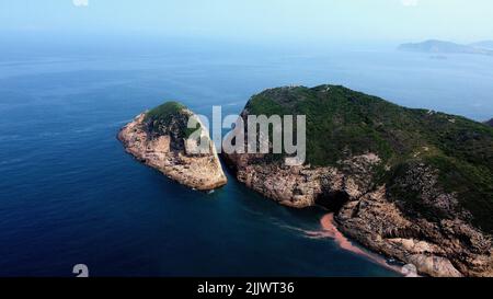 Un colpo ad angolo alto del bacino idrico dell'isola di East Dam High, Hong Kong in una giornata di sole. Foto Stock