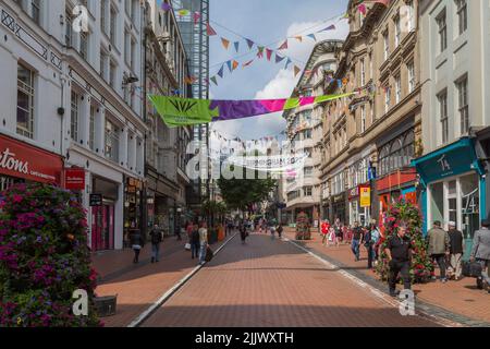 I turisti e la gente del posto camminano tra i negozi del centro di Birmingham durante i Giochi del Commonwealth di Birmingham del 2022. Foto Stock