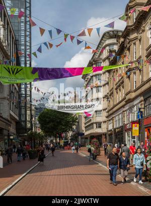 I turisti e la gente del posto camminano tra i negozi del centro di Birmingham durante i Birmingham Commonwealth Games 2022. Foto Stock