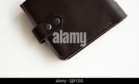 Portafogli in vera pelle marrone scuro realizzati a mano su sfondo bianco. Articoli in pelle e accessori. Foto Stock