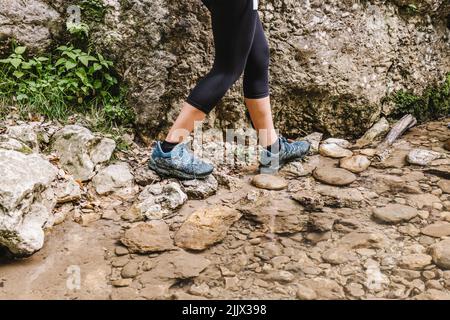 Coltivare femmina escursionista a piedi da roccia rocciosa nella foresta Foto Stock