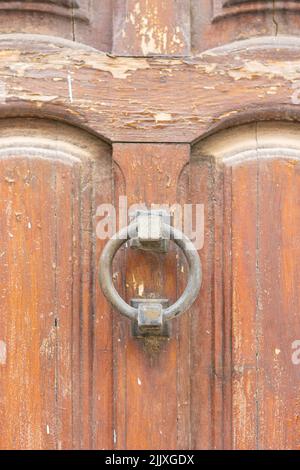 Bussare rotondo arrugginito su una vecchia porta di legno, con spazio copia Foto Stock