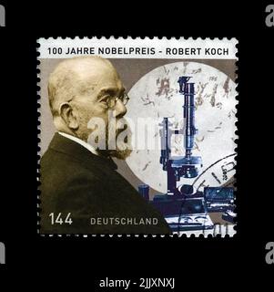 Robert Koch (1843-1910), scopritore prevenire del bacillo tubercolare, premio Nobel di medicina, circa 2005. Timbro stampato in Germania isolato su nero Foto Stock