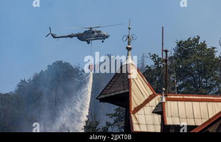 Hrensko, Repubblica Ceca. 28th luglio 2022. L'elicottero dell'esercito ceco mi-17 versa l'acqua dal Bucket Bambi vicino a Hrensko nel Parco Nazionale di Ceske Svycarsko (Svizzera Ceca), Repubblica Ceca, 27 luglio 2022. L'incendio nel parco nazionale si è diffuso per il quarto giorno consecutivo. Credit: Vojtech Hajek/CTK Photo/Alamy Live News Foto Stock