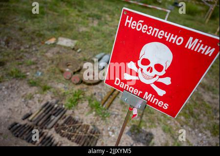 Hostomel, Ucraina. 25th luglio 2022. Sul terreno dell'aeroporto Antonov è un'area di addestramento per la rimozione di mine e ordigni esplosivi. Sul bordo c'è un cartello di avvertimento con l'iscrizione 'Danger Mines'. Credit: Christophe Gateau/dpa/Alamy Live News Foto Stock